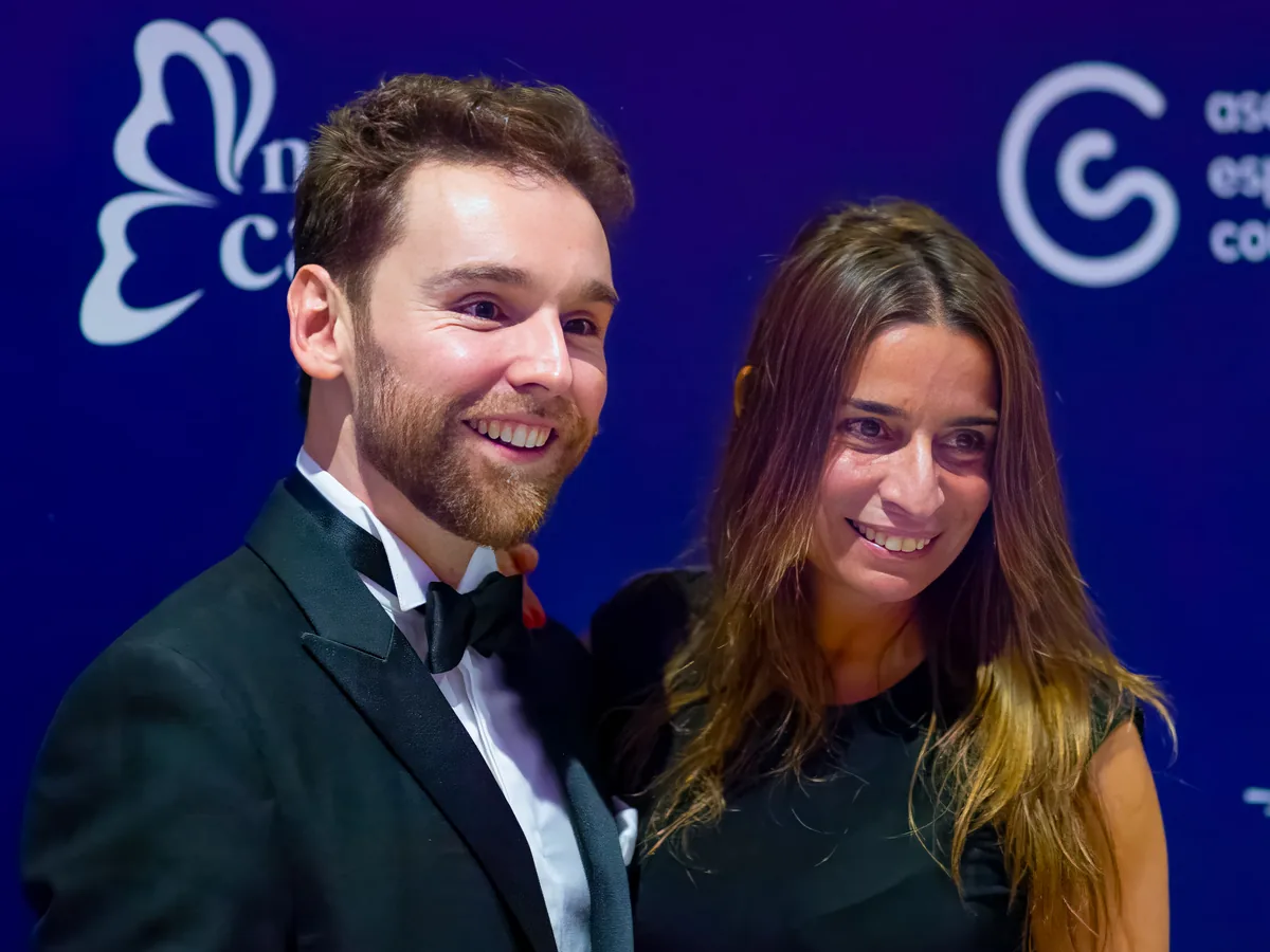 Una pareja de asistentes sonríe ante el photocall de la gala benéfica